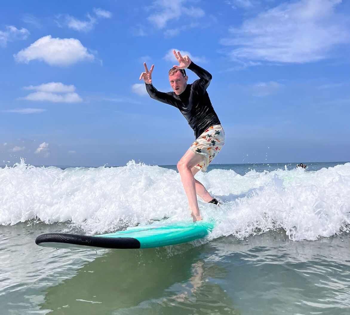 Group surf lesson with students practicing on the beach