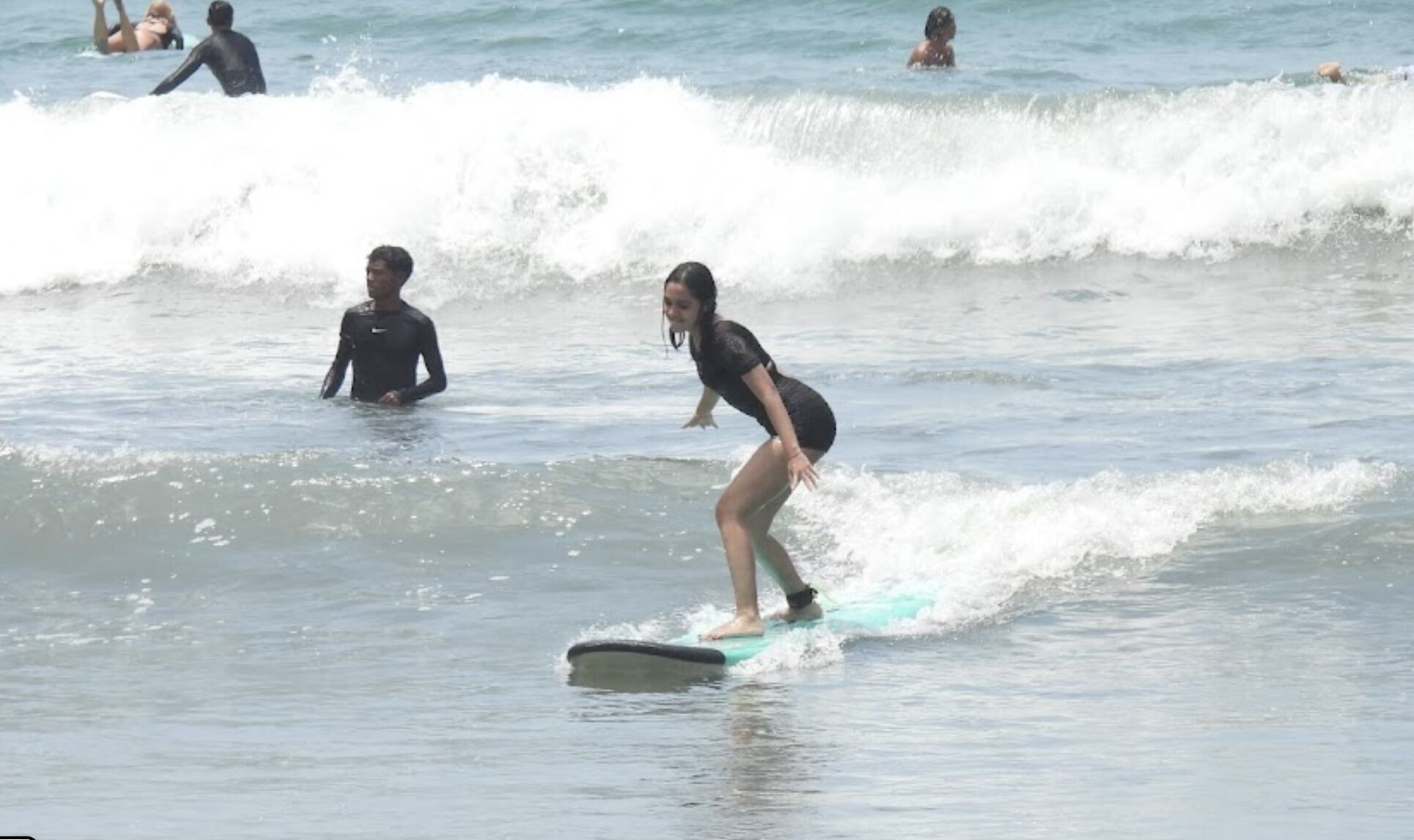 Student practicing wave riding techniques with instructor guidance